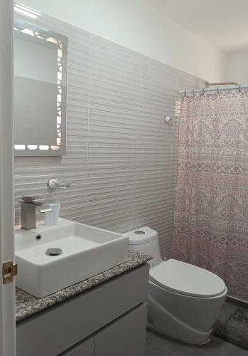 a bathroom with a white sink and a toilet at Yaque Breeze - Beach Apartament in El Yaque