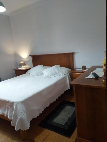 a bedroom with a bed and a desk with a telephone at Casa da Maria in Amoreira