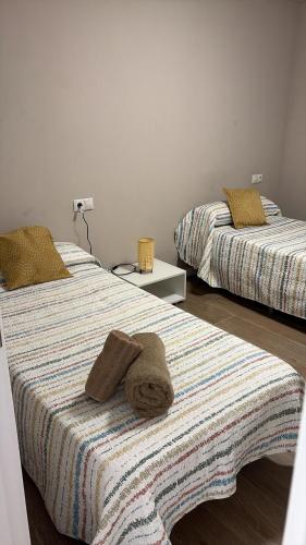 two beds with towels on them in a room at Hostal Vaticano in Alfajarín