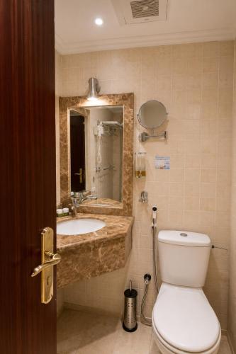 a bathroom with a sink and a toilet and a mirror at فندق مرجانة الحجاز مكة المكرمة in Mecca