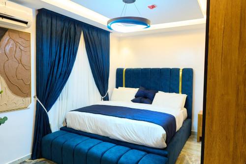 a bedroom with a blue bed with a blue curtain at Apartment60 in Lagos