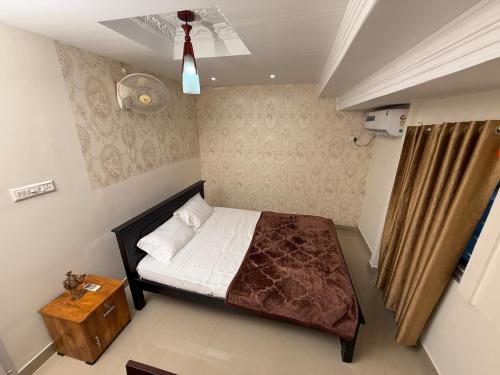 a small bedroom with a bed and a fan at The Villa Mahogany in Trivandrum