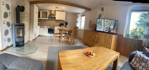a living room with a table and a kitchen at Am Holundergrund in Kurort Gohrisch
