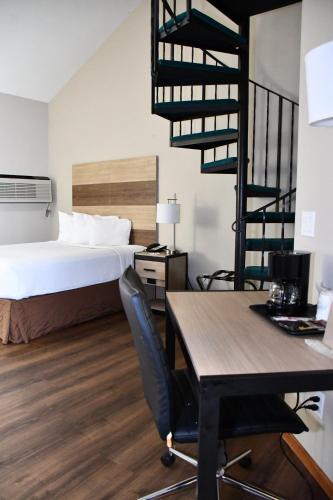 a bedroom with a bed and a desk with a chair at Baymont Inn And Suites by Wyndham Platteville in Platteville