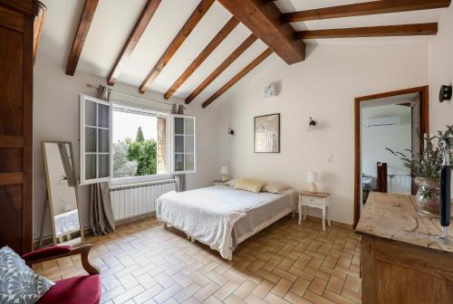 a bedroom with a bed and a large window at Maison de campagne mas Célestin in Camaret-sur-Aigues