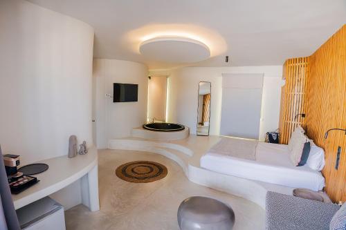 a living room with a bed and a tub in it at Onar Hotel & Suites in Tinos