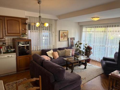 a living room with a couch and a table at Safely located apartment in Prishtinë