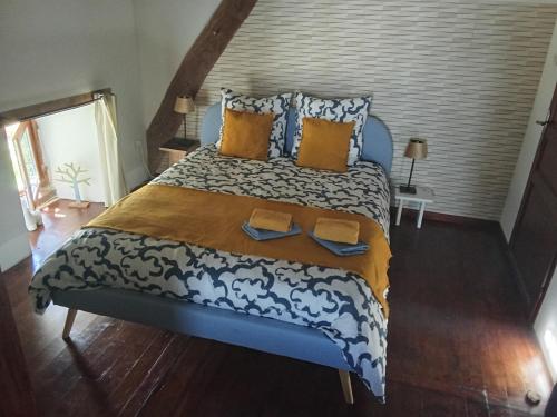 a bedroom with a large bed with yellow and blue pillows at Le Monticule in Tardes