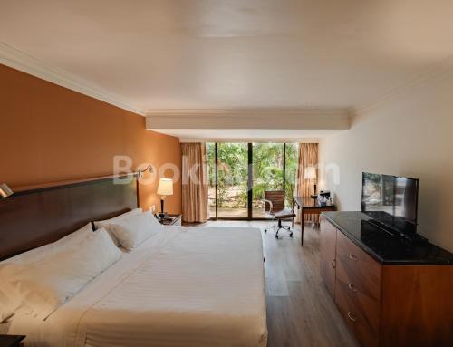 a bedroom with a large bed and a desk at HS HOTSSON Hotel Tampico in Tampico