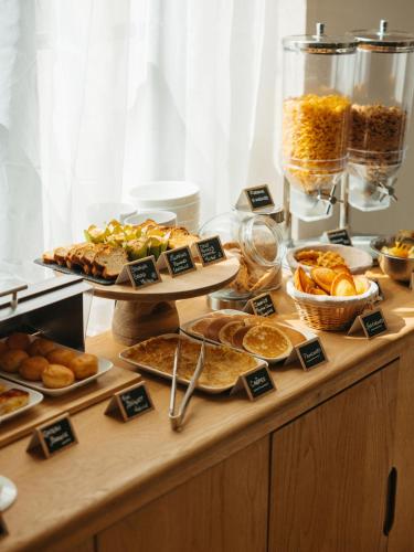 a buffet with various types of bread and pastries at Hotel de Paris in La Rochelle