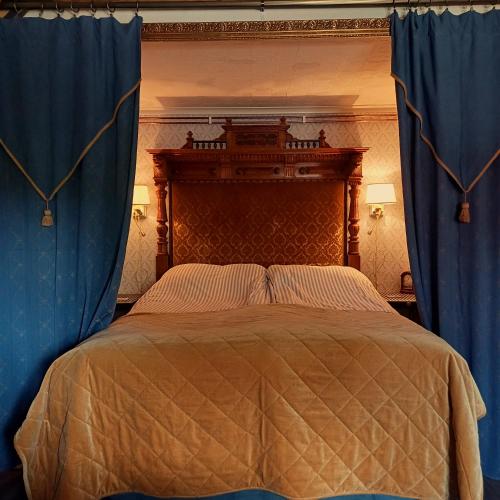 a bedroom with a bed with blue curtains at Villagatan in Hjo