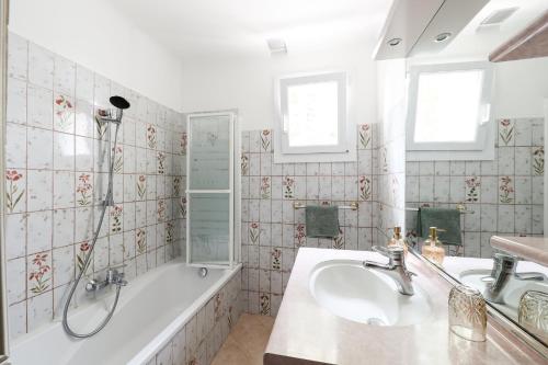 a bathroom with a tub and a sink and a shower at Maison de campagne mas Célestin in Camaret-sur-Aigues