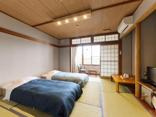 a bedroom with two beds and a tv in it at mt. inn(マウントイン） in Nihommatsu