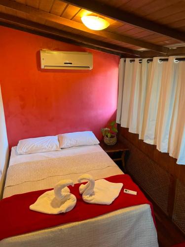 Zwei Schwanenhandtücher liegen auf einem Bett in einem Zimmer in der Unterkunft Biergarten Hostel in Abraão