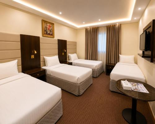 a hotel room with two beds and a television at فندق مرجانة الحجاز مكة المكرمة in Mecca