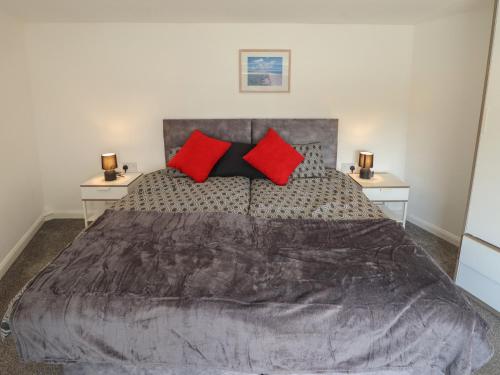 a bedroom with a large bed with red pillows at Number 3 Old Boston Road in Lincoln