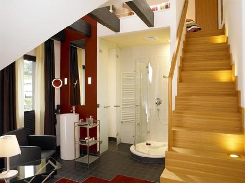 a hallway with a bathroom with a shower and a staircase at Hotel Antoniushütte in Balve