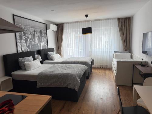 a hotel room with two beds and a couch at Maxim City Apartment in Mainz