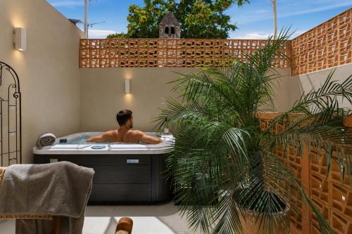a man in a bath tub in a backyard at Asikiko Suites in Rethymno