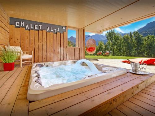 a hot tub sitting on a wooden deck at Chalet Alti - OVO Network in Le Grand-Bornand
