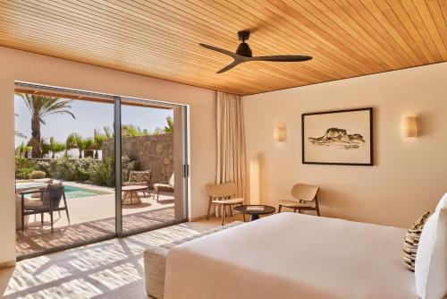 a bedroom with a bed and a view of a patio at Fouquet's Mykonos in Mikonos