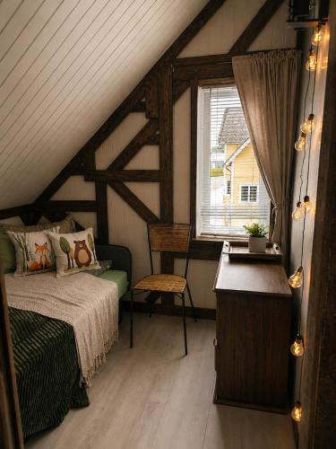 a attic bedroom with a bed and a window at Timber loft in Vigra