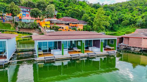 a group of houses on a dock in the water at Raya Buri Resort Kanchanaburi in Ban Hin Hak