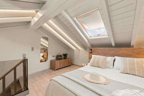 a bedroom with a large bed and a skylight at Asikiko Suites in Rethymno