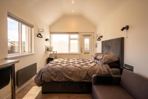 a bedroom with a bed and a window and a couch at Cushendall Coastal Accommodation, Glens of Antrim - Beach & Mountain Access in Cushendall