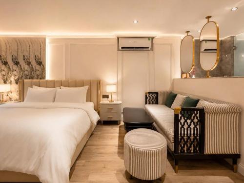 a hotel room with a bed and a couch at My Eliana Luxury Hotel Saigon Saigon & Spa in Ho Chi Minh City