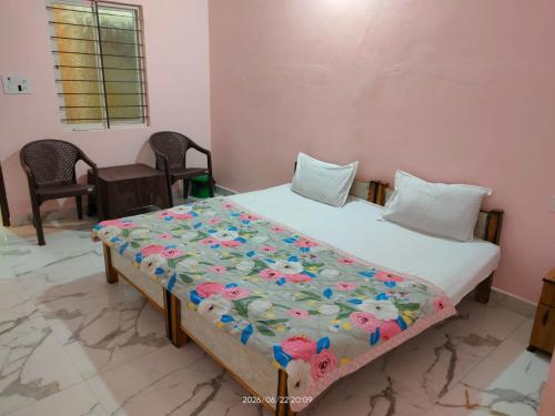 a bedroom with a bed with a quilt on it at Hotel Madhur Palace in Bhopal