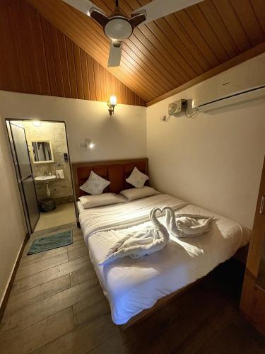 a bedroom with two beds and a mirror at Rimzim's Tatvamasi - A Pool Villa Retreat in Kudāl