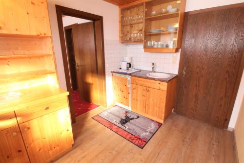 małą kuchnię z drewnianymi szafkami i zlewem w obiekcie Ivos Sonnenpension w mieście Leutasch
