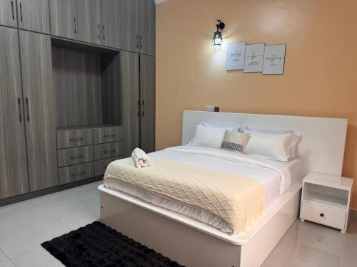 a bedroom with a large white bed in a room at Mallony Homes in Kampala