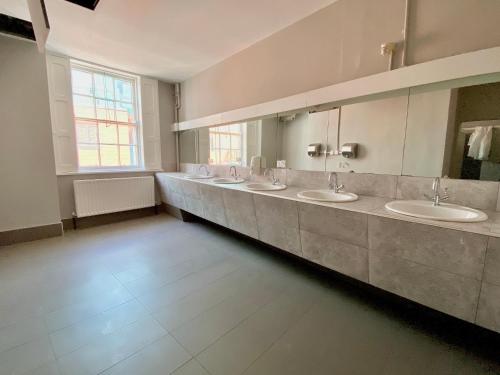 a bathroom with four sinks and a row of mirrors at Leevin Stay Hostel in Dublin