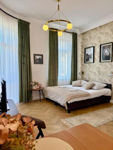a bedroom with a bed and a living room at Apartament Verde Stare Miasto in Chełm