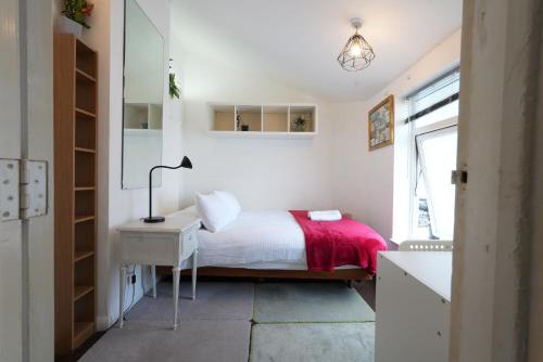 a bedroom with a bed and a desk and a window at Cosy 3BR House, 2 Bath, Near Luton Centre in Luton