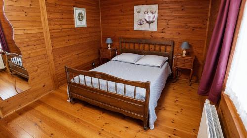 a bedroom with a bed in a wooden room at Le chalet du mazagran in Leffincourt