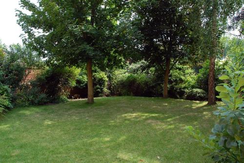 a large yard with two trees and grass at Woodlands Hotel in Spalding