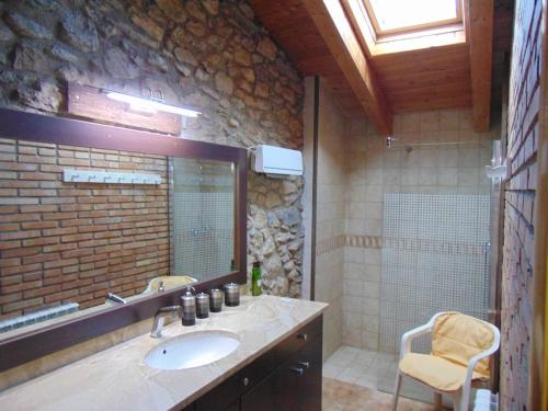 a bathroom with a sink and a stone wall at Era Cal Anton in Alás