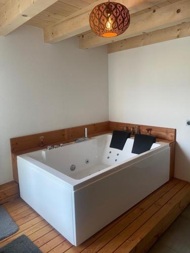 a large white bath tub in a room with a ceiling at Bulle de rêve jacuzzi in Bulle