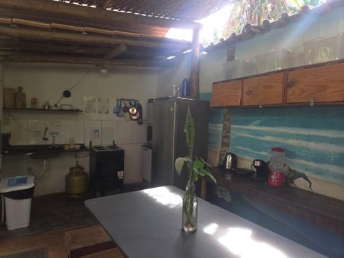 a kitchen with a table with a vase on a table at Villa Residencial Encantos Da Mata in Itacaré