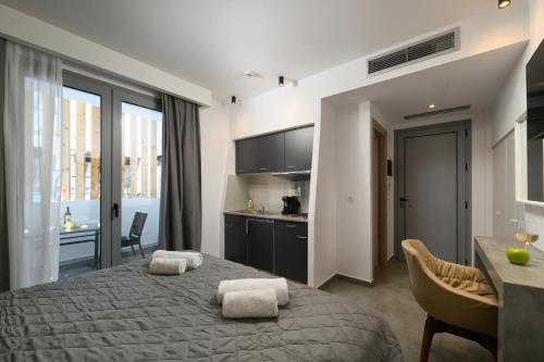a bedroom with a bed and a kitchen and a table at Angelo Boutique Hotel Santorini in Perissa