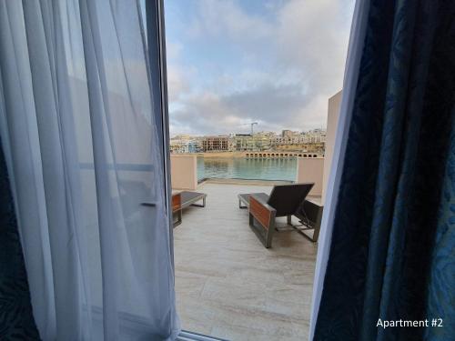 Una vista de un balcón con vista al agua. en Marbella Holiday Apartments - Seafront - Wifi, en Marsaskala