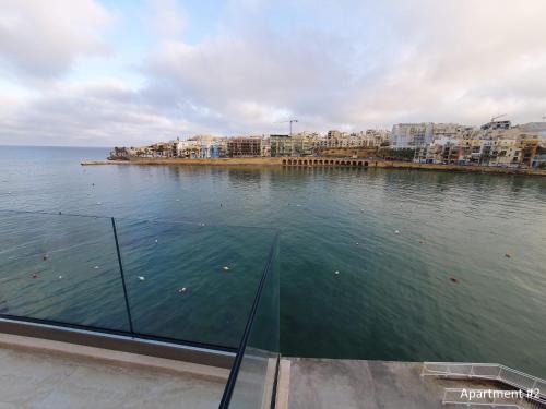 Una vista de un cuerpo de agua con edificios. en Marbella Holiday Apartments - Seafront - Wifi, en Marsaskala