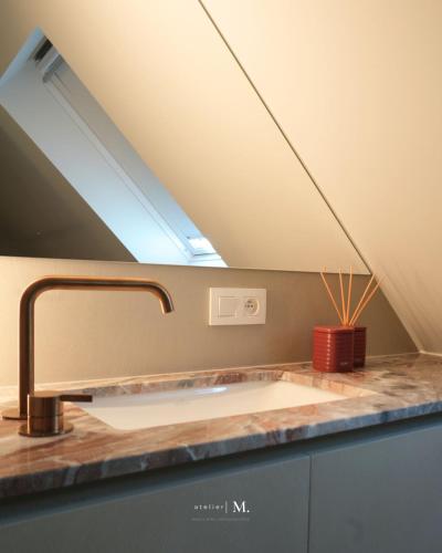 a bathroom with a sink and a skylight at Atelier M in Kruisem