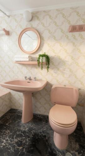 a bathroom with a pink toilet and a sink at Kineta Prime Suites No2 in Kineta