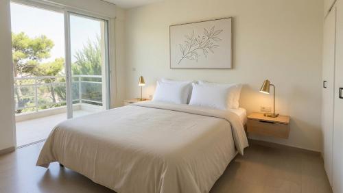 a white bedroom with a bed and a large window at Kineta Prime Suites No2 in Kineta