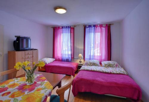 a bedroom with two beds and a table with a vase of flowers at Biotanika in Michałkowa