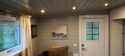 a room with a door and a chair and a window at Stetind Skicamp in Lyngen